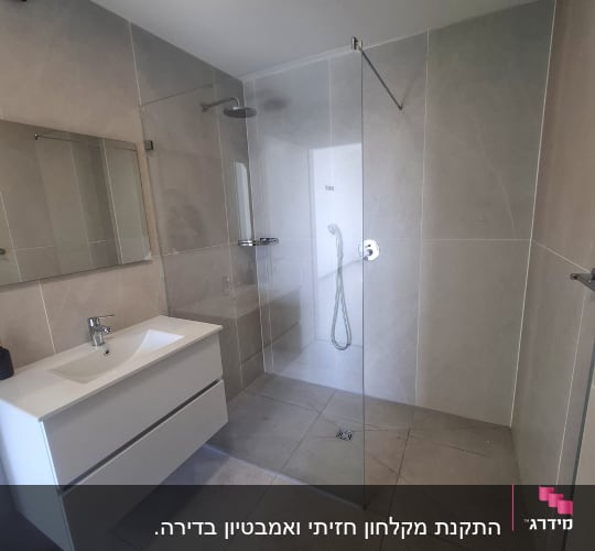 מקלחת עם דלת זכוכית וכיור לבן